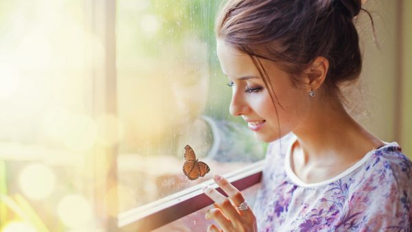 Девочка улыбается бабочке 