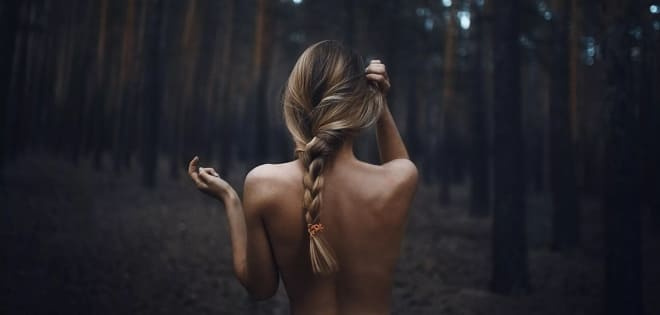 Обнаженная женщина делает магию на природе
