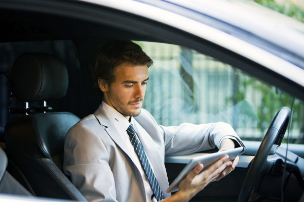 Мужчина с планшетом в автомобиле.